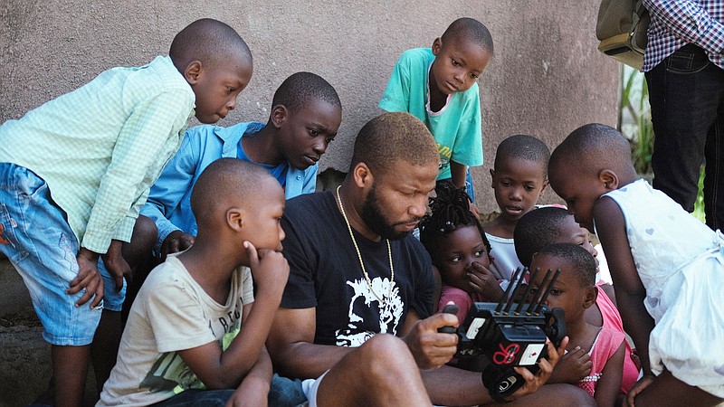 Children gathered around Dui Jarrod while he was filming in Tanzania. (Special to The Commercial)