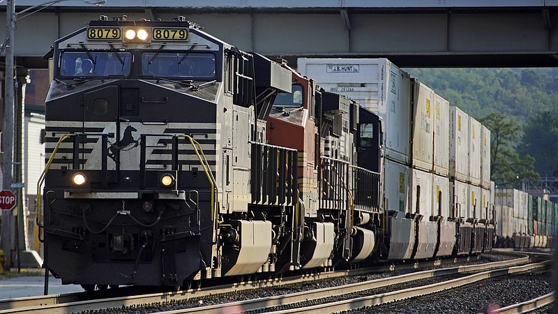 FILE - A Norfolk Southern freight train runs through a crossing on Sept. 14, 2022, in Homestead, Pa. The railroad union that rejected its deal with the nation's freight railroads earlier this month even though it offered 24% raises now has a new tentative agreement, but officials cautioned that the contract dispute won't be fully settled until all 12 rail unions approve their agreements this fall. (AP Photo/Gene J. Puskar, File)