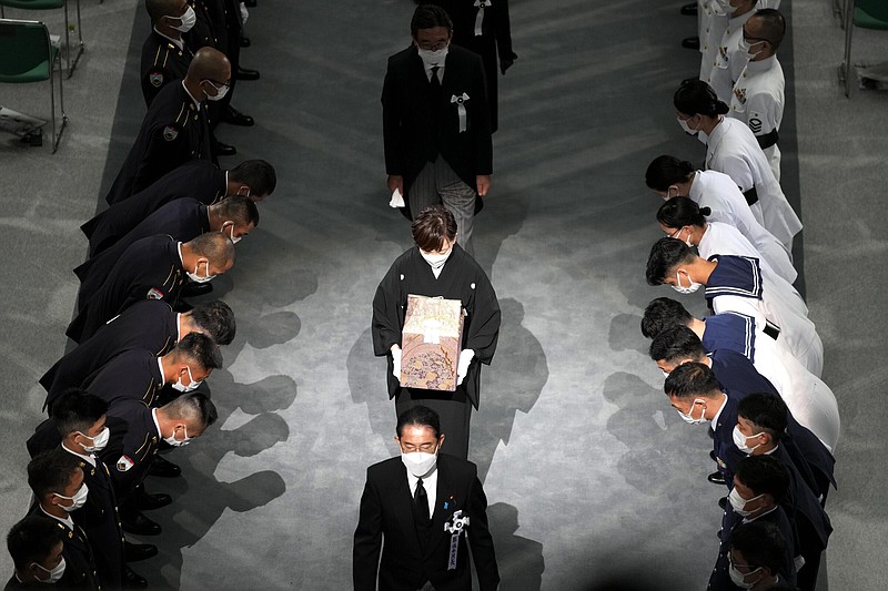 Akie Abe, center, wife of former Japanese Prime Minister Shinzo Abe, carries her husband's urn, as she follows Japan's Prime Minister Fumio Kishida while leaving the state funeral for Abe at Nippon Budokan Hall, in Tokyo, Tuesday, Sept. 27, 2022. ((Kyodo News via AP)