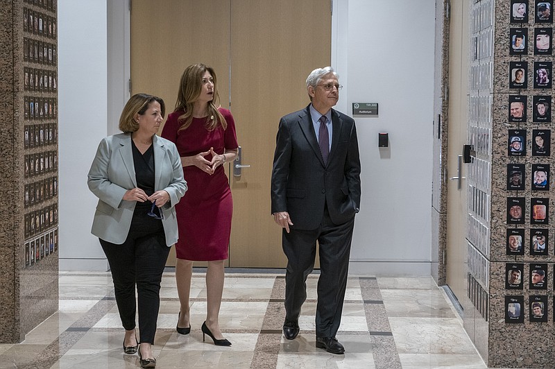 Attorney General Merrick Garland, right, Deputy Attorney General Lisa Monaco, left, and Drug Enforcement Administration Administrator Anne Milgram walk through the exhibition of "The Faces of Fentanyl" wall at DEA headquarters before a press event Tuesday, Sept. 27, 2022, to announce the results of an enforcement surge to reduce the fentanyl supply across the United States, at DEA headquarters, Arlington, Va. (AP Photo/Gemunu Amarasinghe)