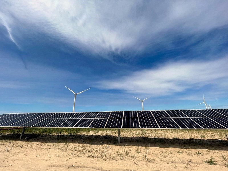 In this image provided by Portland General Electric, windmills and solar panels line a renewable energy facility May 24, 2022, in Lexington, Ore. The facility combines solar power, wind power and massive batteries to store the energy generated there. The Wheatridge Renewable Energy Facilities was commissioned Wednesday, Sept. 28, 2022, and is the first utility-scale plant of its kind in North America. Clean energy experts say the project, which can power 100,000 homes, addresses some key challenges facing the industry as the U.S. transitions away from fossil fuels. (Sarah Hamaker/Portland General Electric via AP)