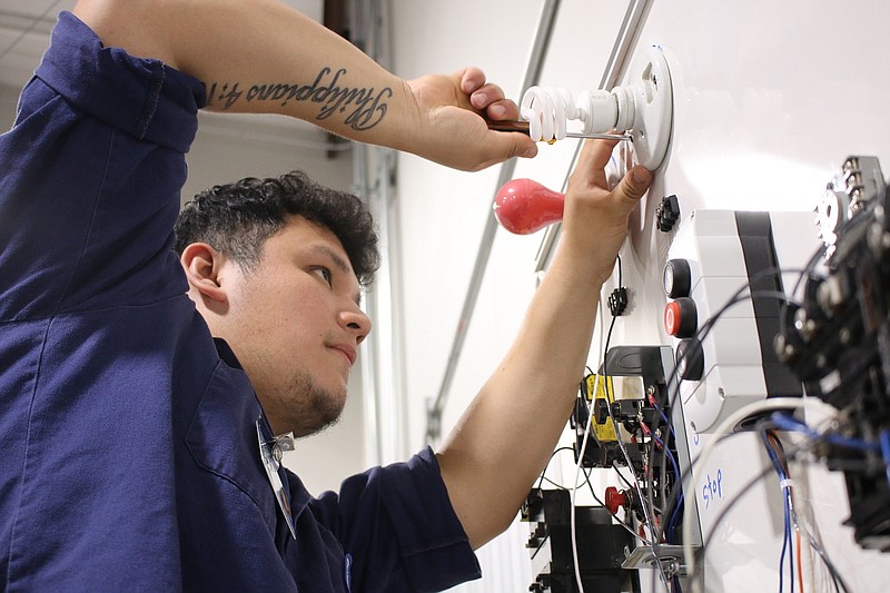A Texarkana College electrical technology student secures a light fixture after wiring it. (Photo courtesy Texarkana College)