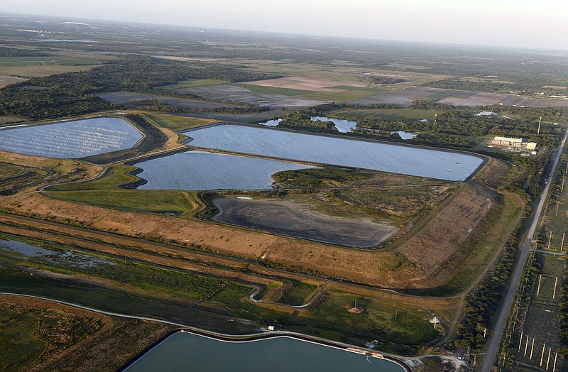 FILE - This aerial photo taken from an airplane shows a reservoir near the old Piney Point phosphate mine on April 3, 2021, in Bradenton, Fla. The polluted leftovers of Florida's phosphate fertilizer mining industry, more than 1 billion tons in “stacks” that resemble enormous ponds, are at risk for leaks or other contamination triggered by Hurricane Ian, said environmental groups Tuesday, Sept. 27, 2022. (Tiffany Tompkins/The Bradenton Herald via AP, File)