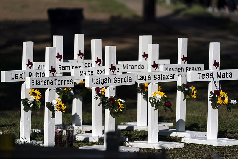 Crosses with the names of shooting victims are placed outside Robb Elementary School on May 26, 2022, in Uvalde, Texas. A federal lawsuit was filed Wednesday, Sept. 28, 2022, in Del Rio, Texas, against eight entities and three individuals for the May shooting that killed 19 students and two teachers at the elementary school. (AP Photo/Jae C. Hong, File)
