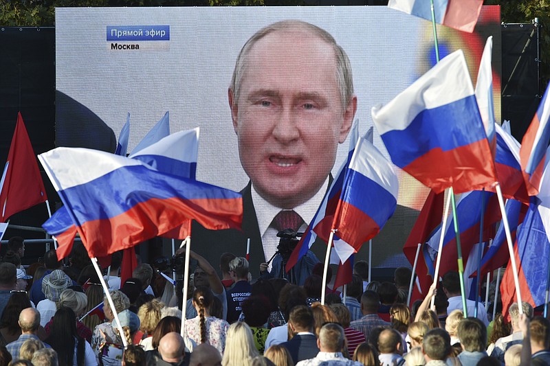 People watch on a large screen, as Russian President Vladimir Putin delivers his speech after a ceremony to sign the treaties for four regions of Ukraine to join Russia in Moscow's Kremlin, during a meeting in Sevastopol, Crimea, Friday, Sept. 30, 2022. The signing of the treaties making the four regions part of Russia follows the completion of the Kremlin-orchestrated &quot;referendums.&quot; (AP Photo)