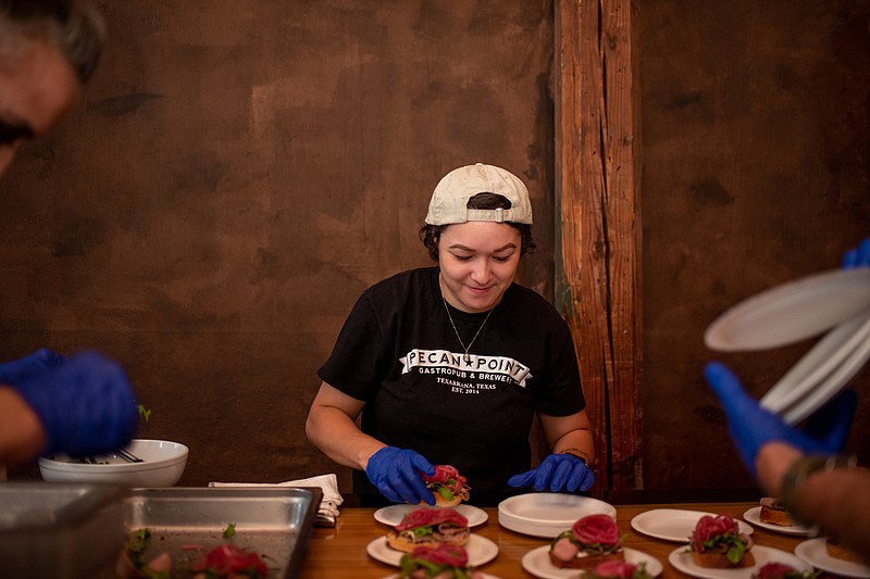 Pecan Point manager Cali Gudino plates an open-faced prime rib sandwich at a VIP pre-event at Crossties Event Venue on Friday evening during the Greater Texarkana Young Professionals' annual Destination Downtown event.  (Staff photo by Erin DeBlanc)