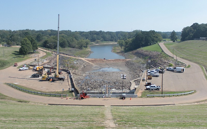 U.S. Army Corps of Engineers and contractors work on the Wright Patman Lake spillway Thursday, Sept. 29, 2022, in Texarkana, Texas. The Sulphur River is seen in the background, with a cofferdam separating it from the basin. The spillway basin is being resurfaced to repair eroded areas. Lake manager Matt Seavey expects the work to be completed by mid-October. (Staff photo by Stevon Gamble)