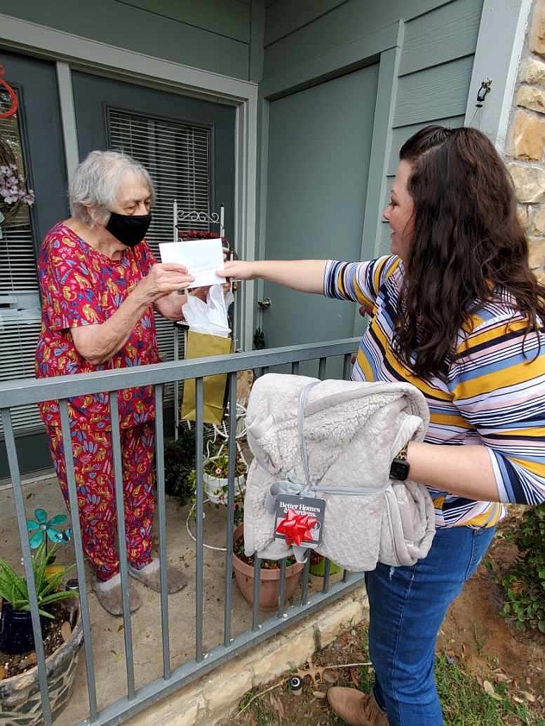 Senior Transportation client Barbara Waddell receives her Cozy Christmas Drive goodies from Shanna Mudford, HandsOn Texarkana's administrative assistant and transportation coordinator. (Photo courtesy of Amy Lemley)