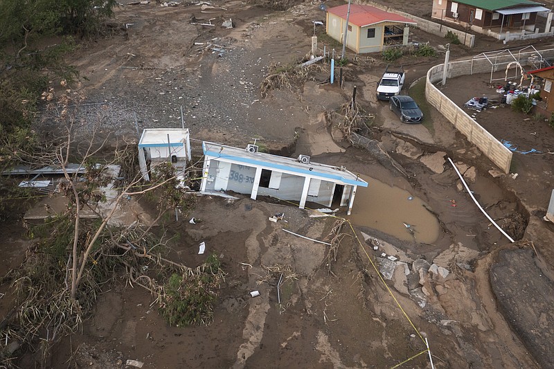 FILE - A house lies in the mud after it was washed away by Hurricane Fiona at Villa Esperanza in Salinas, Puerto Rico, Wednesday, Sept. 21, 2022. On Monday, Oct. 3, 2022, President Joe Biden will survey damage from Hurricane Fiona in Puerto Rico, where tens of thousands of people are still without power two weeks after the storm hit. (AP Photo/Alejandro Granadillo, File)