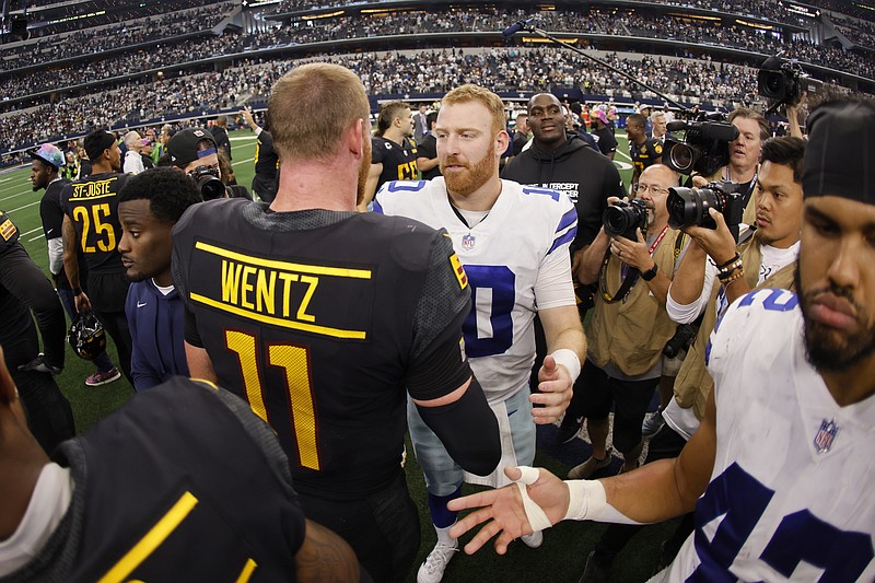 Washington Commanders' Carson Wentz (11) and Dallas Cowboys' Cooper Rush, center right, greet each other after their team's NFL football game in Arlington, Texas, Sunday, Oct. 2, 2022. (AP Photo/Ron Jenkins)