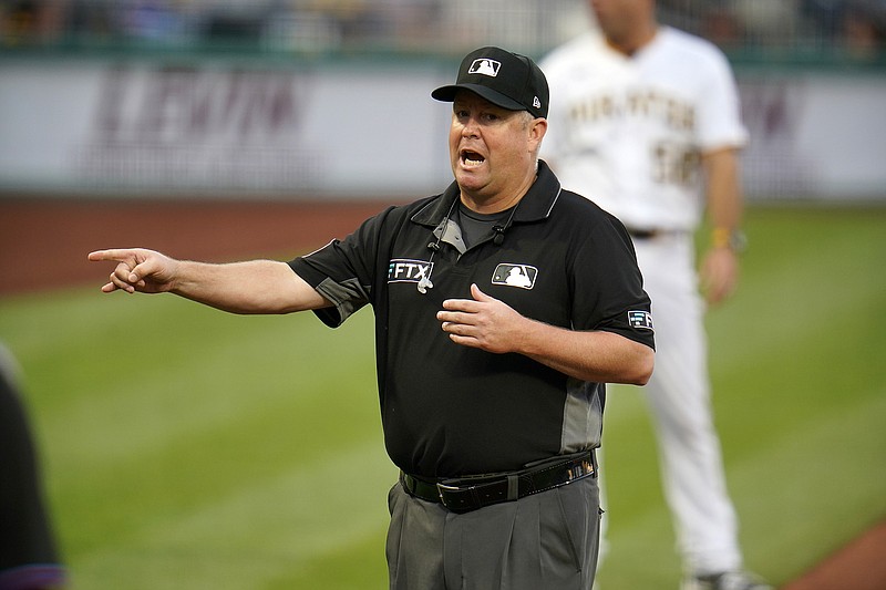 Umpire crew chief Todd Tichenor announces the outcome of a play review during a baseball game between the Pittsburgh Pirates and the Miami Marlins in Pittsburgh, Saturday, July 23, 2022. The notion of hearing a mic'd-up ump's voice explaining something feels oddly revolutionary, even after nearly an entire season of hearing it off and on. (AP Photo/Gene J. Puskar)