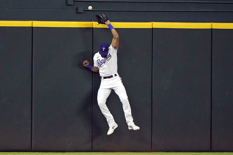 Texas Rangers center fielder Leody Taveras jumps at the wall but can't reach the home run hit by New York Yankees' Kyle Higashioka during the eighth inning in the first baseball game of a doubleheader in Arlington, Texas, Tuesday, Oct. 4, 2022. (AP Photo/LM Otero)
