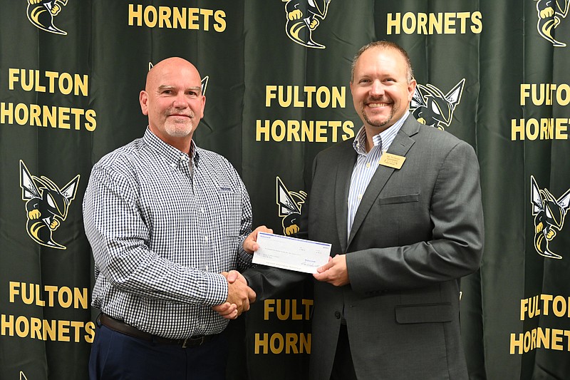 Kevin Werdehausen, general manager for the Fulton Walsworth, presents a check for $2,500 to Fulton Public Schools Superintendent Ty Crain. (Submitted photo)