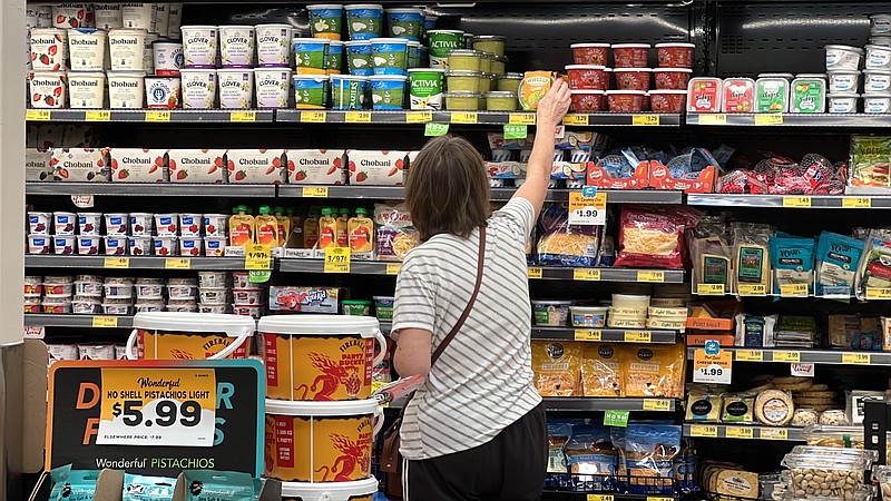 A customer looks at refrigerated items at a Grocery Outlet store in Pleasanton, Calif.,. on Thursday, Sept. 15, 2022.  "Best before” labels are coming under scrutiny as concerns about food waste grow around the world. Manufacturers have used the labels for decades to estimate peak freshness. But “best before” labels have nothing to do with safety, and some worry they encourage consumers to throw away food that’s perfectly fine to eat.  (AP Photo/Terry Chea)