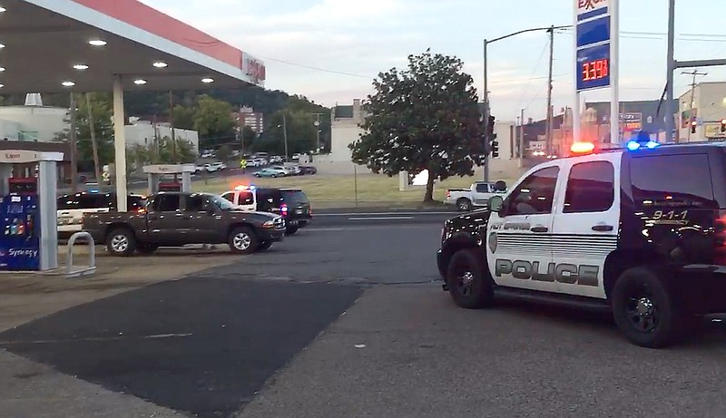 Hot Springs police units block off the front parking area at the Exxon station at Grand and Central avenues Wednesday evening where one alleged shooting victim was located. - Photo by Steven Mross of The Sentinel-Record