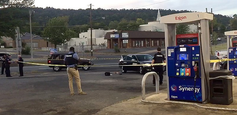 Hot Springs police work near a vehicle that carried a 17-year-old female gunshot victim to the parking lot of Exxon, 1200 Central Ave., shortly before 6:30 p.m. Wednesday following a triple shooting on School Street where another teen was killed. - Photo by Steven Mross of The Sentinel-Record