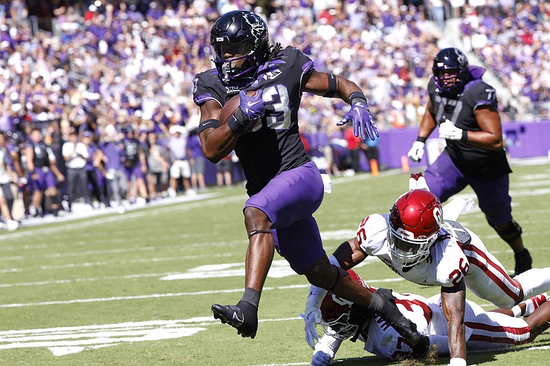 TCU running back Kendre Miller (33) escapes the grasp of Oklahoma defensive back Kani Walker (26) to score a touchdown Saturday in Fort Worth, Texas. - Photo by Ron Jenkins of The Associated Press