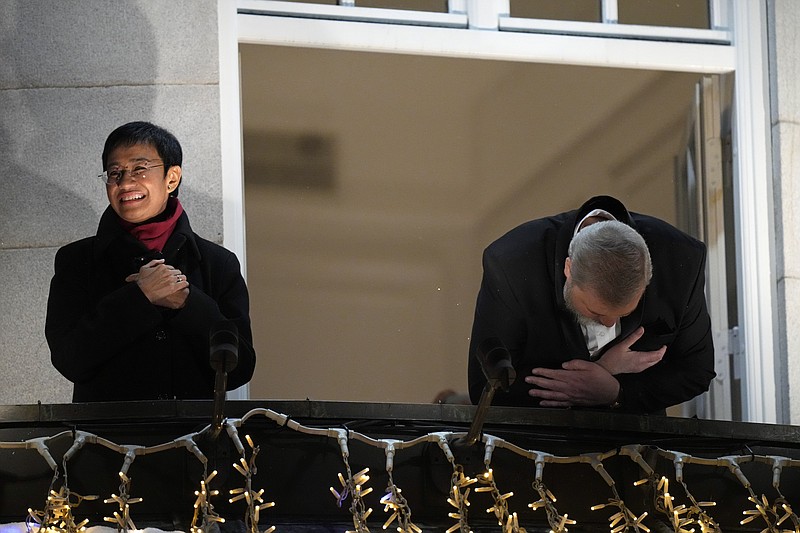 La filipina María Ressa (izq) y el ruso Dmitry Muratov saludan desde un balcón del Grand Hotel de Oslo tras la ceremonia de entrega del Premio Nobel de la Paz el 10 de diciembre del 2021. El premio no redujo el hostigamiento de que son blanco en sus países. (AP Photo/Alexander Zemlianichenko, FIle)