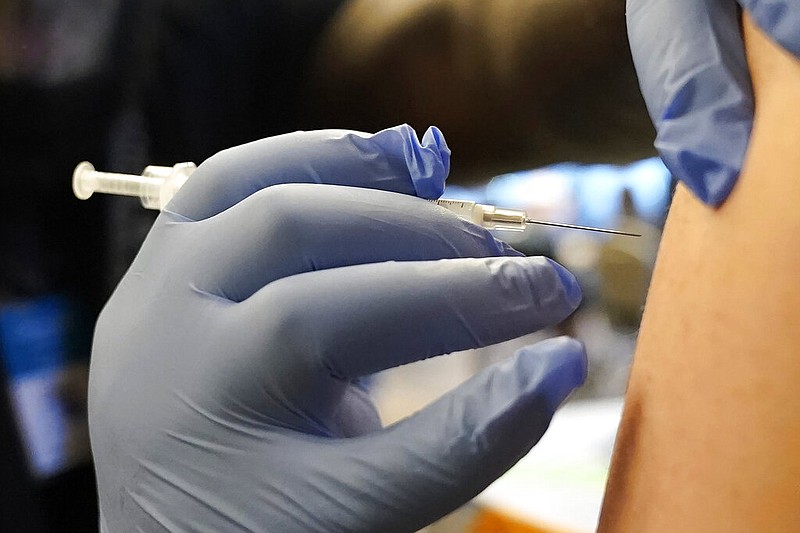 A Pfizer COVID-19 vaccine booster shot is given on Dec. 20, 2021, in Federal Way, Wash. - AP Photo/Ted S. Warren