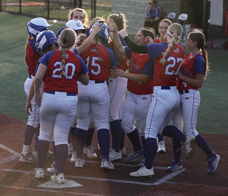 Junior catcher Addie Clay (#15) is met by the Lady Pintos at home plate after hitting a two-run home to tie the game in the fifth inning. (Democrat Photo/Evan Holmes)
