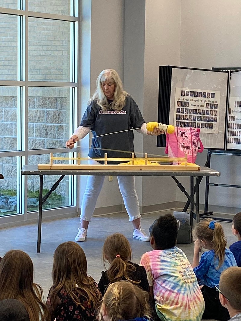 Sandy Gross demonstrates to Parkers Chapel students how she makes yarn wigs for children fighting cancer earlier this year. Elementary students at PC held a yard fundraiser for her and donated 124 skeins of yarn to help make more wigs. (Courtesy of Sandy Gross/Special to Live Union County)