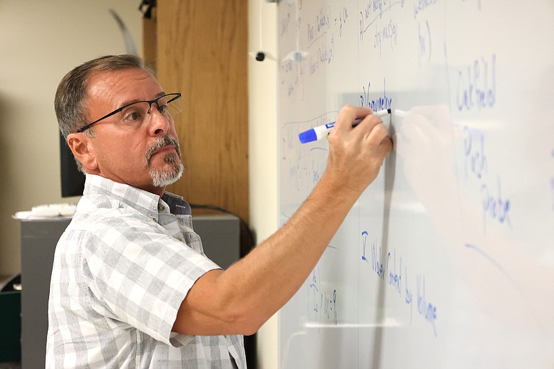 UAM Forestry Professor Robert Ficklin writes notes on the whiteboard during a recent class. (Special to The Commercial/University of Arkansas at Monticello)