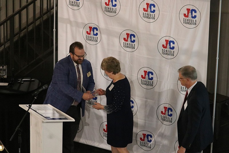 Jacob Robinett of the JC Schools Foundation, left, presents Brenda and Fred Proebsting with the Brenda Hatfield Service Award. (Anna Campbell/News Tribune)