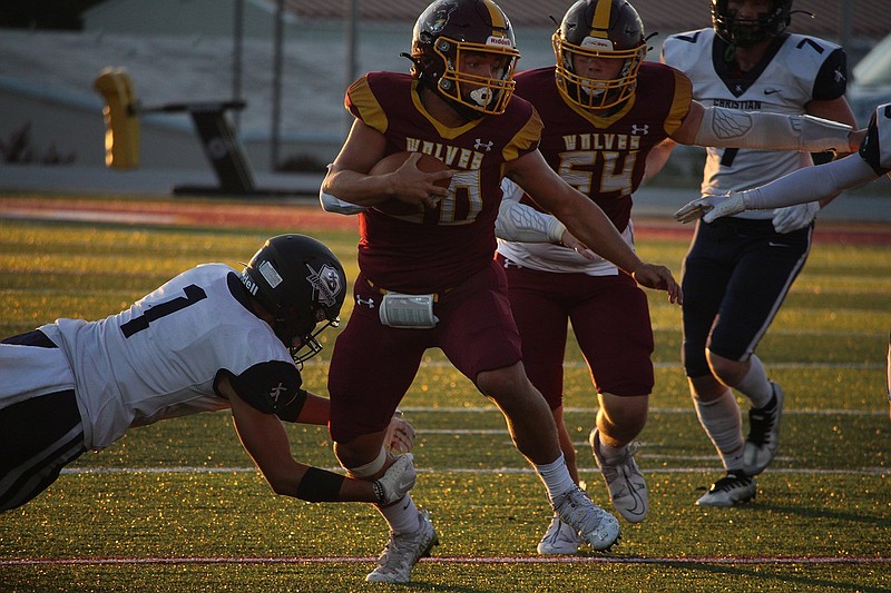 Lake Hamilton's Izic Clenney (20) sheds a tackle by Little Rock Christian's Jacob Field (1) Sept. 9 at Wolf Stadium. - Photo by Krishnan Collins of The Sentinel-Record