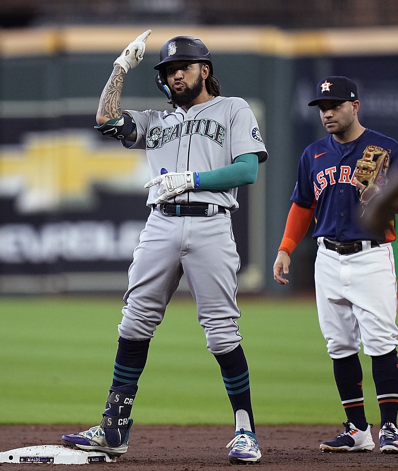 Seattle Mariners' J.P. Crawford, left, reacts after hitting a