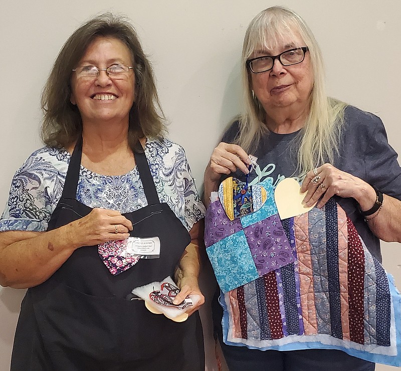 Jody Stout (left) and Patsy Brown display hearts and materials for the service project of the Grace Willing Workers – Traveling With Grace Club. (Special to The Commercial)