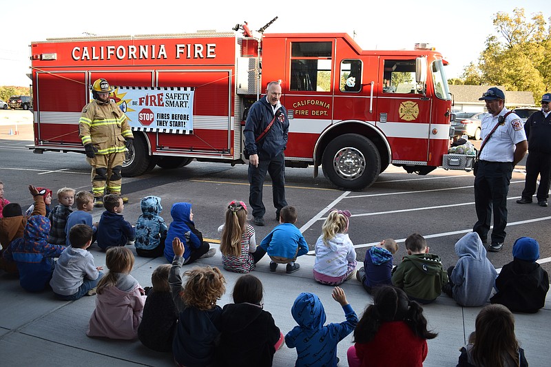 Democrat photo/Garrett Fuller — California Fire Chief Brad Friedmeyer, center, answers questions from pre-kindergarten students Friday (Oct. 14, 2022,) during California Fire Department's visit to California Elementary School for Fire Prevention Week. Firefighter Brandon Embry, left, and Deputy Fire Chief Jay Fortner joined Friedmeyer in introducing fire safety to the children.