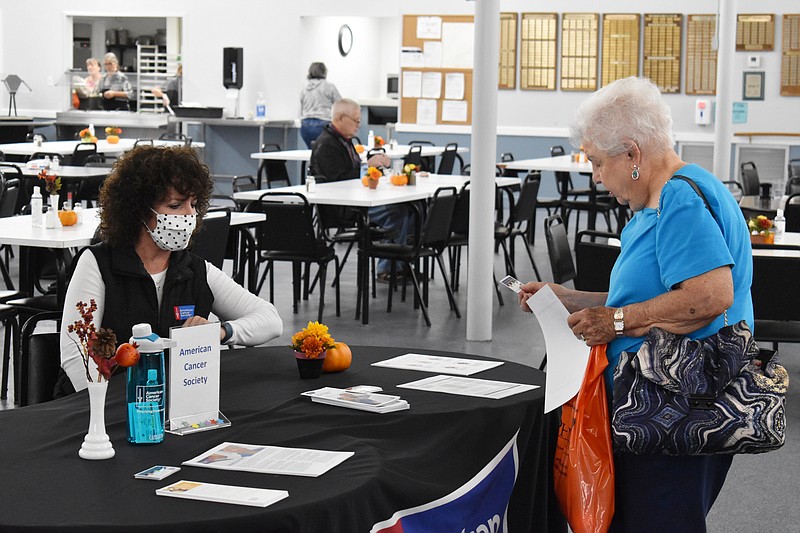 Democrat photo/Garrett Fuller — D'Arcy Crane, left, associate director for the Mid-Missouri Market of the American Cancer Society, talks about the organization Friday (Oct. 14, 2022,) with Bonnie Muri at the California Nutrition Center's "Check Into Your Health" health fair.