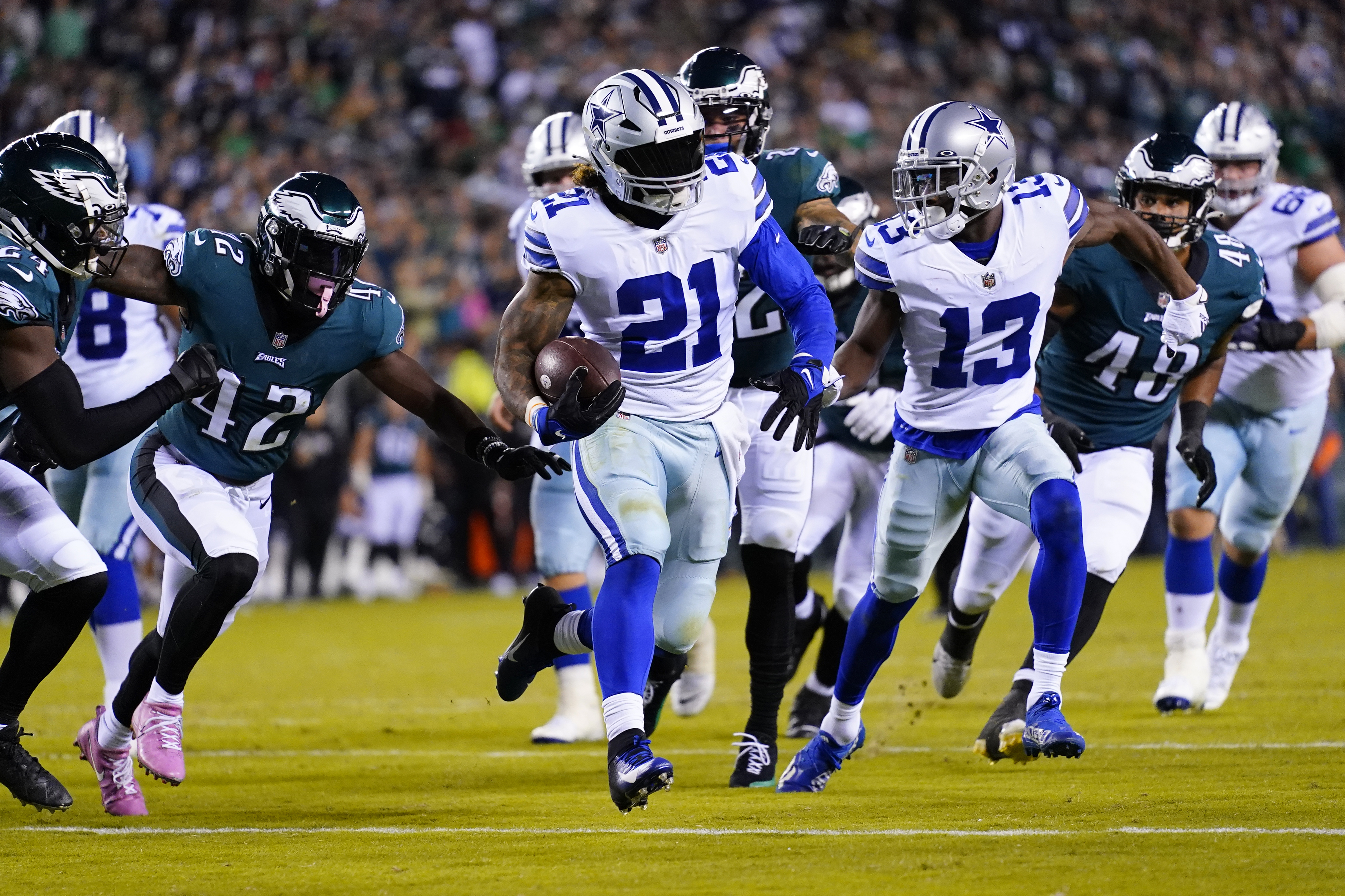 Arlington, United States. 24th Dec, 2022. Dallas Cowboys Ezekiel Ellott  runs as Philadelphia Eagles T.J. Edwards closes in during their NFL game at  AT&T Stadium in Arlington, Texas on Saturday, December 24