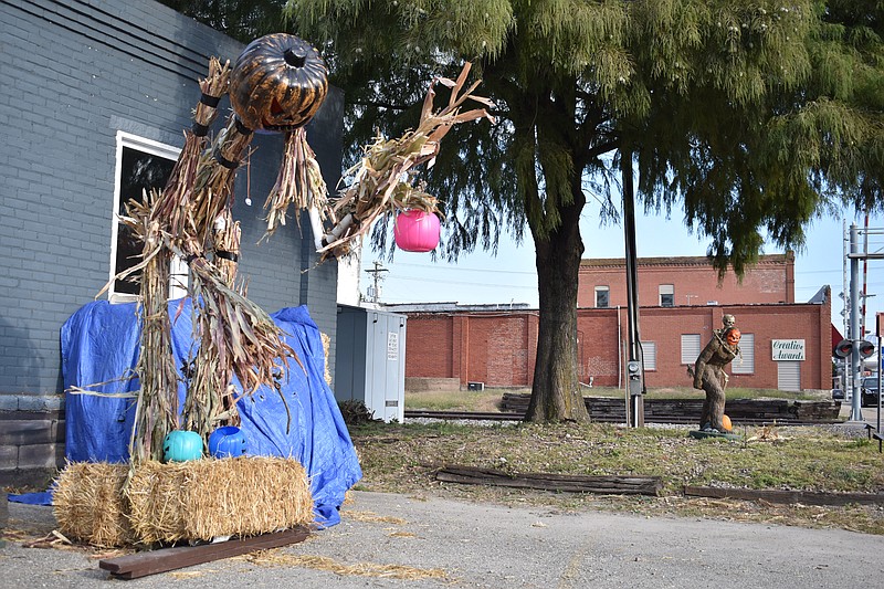 Democrat photo/Garrett Fuller — A pumpkin-headed scarecrow, left, accompanied by a "Grassquatch" and skeleton, is seen Oct. 7, 2022, outside Angel Lawncare welcoming people to downtown California. Erick Angel, owner of Angel Lawncare, said it took a day and a half to make the scarecrow.