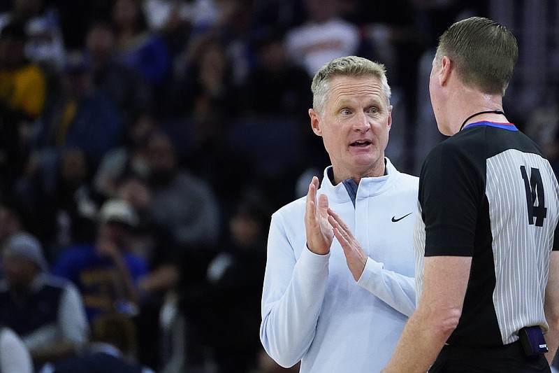 Golden State Warriors coach Steve Kerr talks to referee Ed Malloy (14) after a foul was called on center James Wiseman during the first half of the team's NBA preseason basketball game against the Portland Trail Blazers in San Francisco, Tuesday, Oct. 11, 2022. (AP Photo/Godofredo A. Vásquez)