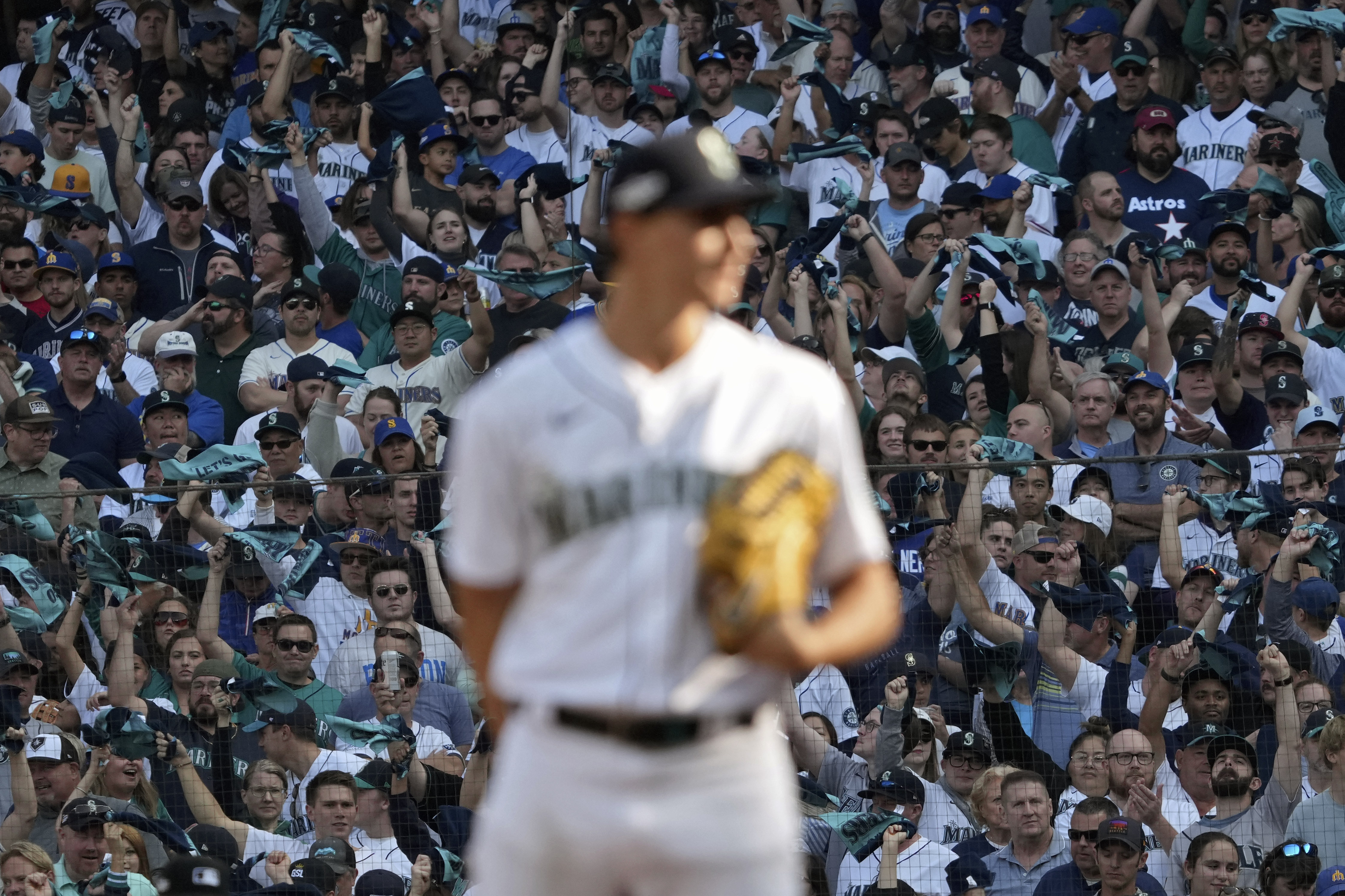 Seattle Mariners' Eugenio Suarez blows a bubble as he waits to bat