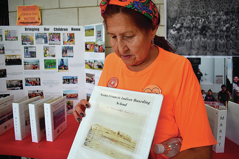 Ruby Left Hand Bull Sanchez holds a binder Oct. 15 featuring a photo of the Native American boarding school she attended as a child on the Rosebud Sioux Reservation in Mission, S.D. (AP/Matthew Brown)