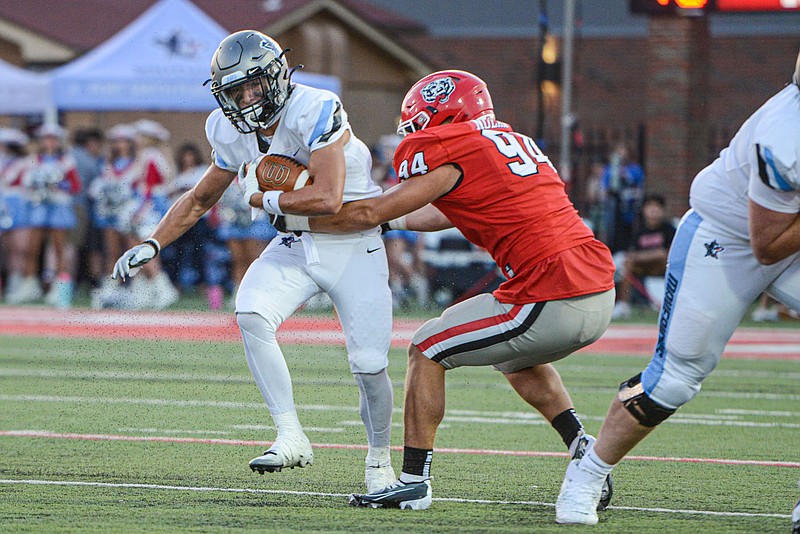 Isaac Gregory (left), of Fort Smith Southside, carries the ball as Josh Nolan, senior defensive lineman for Fort Smith Northside, defends on Friday, August 26, 2022, during the first quarter of the Battle of Rogers Avenue at Mayo-Thompson Stadium in Fort Smith. (NWA Democrat-Gazette/Hank Layton)