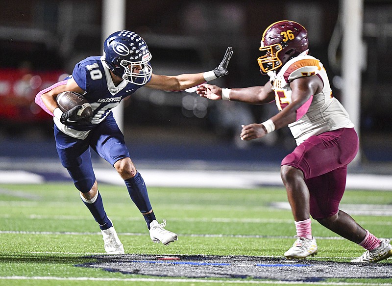 Greenwood wide receiver Peyton Presson (10) attempts to break a tackle by Lake Hamilton’s Jamarrion Byrd Friday during the second quarter at Smith-Robinson Stadium in Greenwood. - Photo by Hank Layton of NWA Democrat-Gazette