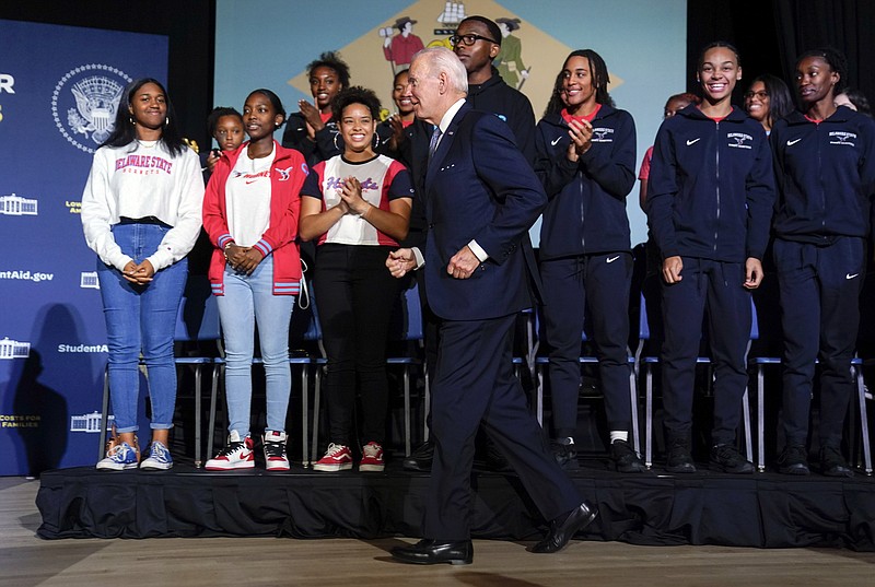 President Joe Biden jogs to the other side of the stage to talk with Delaware State University students after delivering a speech about student loan debt relief at the university on Friday, Oct. 21, 2022, in Dover, Del. (AP Photo/Evan Vucci)