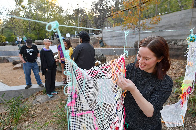 Joy Clark of Art Ventures adds her contribution Friday to a community collaborative textile project led by artist Jeffry Cantu in the Fay Jones Woods at The Ramble in Fayetteville. The city's Arts Council is exploring a proposal to create a 'percent for the arts,' which would dedicate a portion of the budget for city projects to public art. Visit nwaonline.com/221024Daily/ for today's photo gallery. 
(NWA Democrat-Gazette/Andy Shupe)