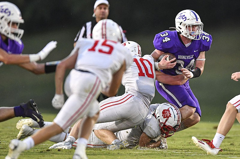 Dax Goff (34) of Booneville carries the ball as Wyatt Simmons (10) and Peyton Cole (30) of Harding Academy pursue, Friday, Sept. 16, 2022, during the first quarter of the Wildcats’ 44-14 win at Bearcat Stadium in Booneville. Visit nwaonline.com/220917Daily/ for today's photo gallery.
(NWA Democrat-Gazette/Hank Layton)