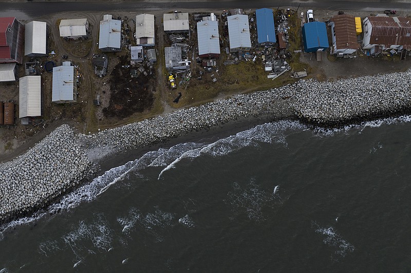 Small waves crash into reinforced seawalls Tuesday, Oct. 4, 2022, in Shishmaref, Alaska. Rising sea levels, flooding, increased erosion and loss of protective sea ice and land have led residents of this island community to vote twice to relocate. But more than six years after the last vote, Shishmaref remains in the same place because the relocation is too costly. (AP Photo/Jae C. Hong)