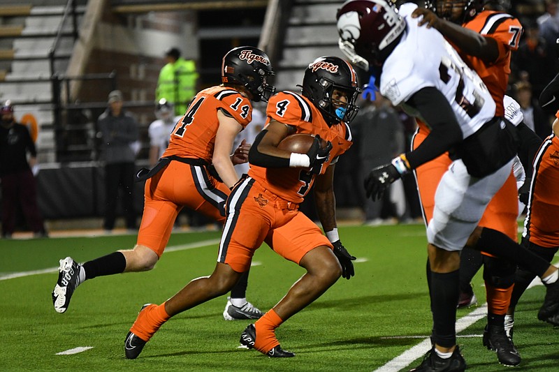 Photo by Kevin Sutton
Texas High running back Javari Johnson (4) cuts upfield after getting the ball from quarterback David Potter (14) while a blocker hits Whitehouse defender Erik Brody (25). The Tigers lost the district game, 32-27.