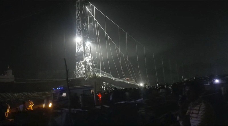 Rescuers work at night after a cable bridge across the Machchu river collapsed in Morbi district, western Gujarat state, India, Sunday, Oct.30, 2022. Dozens are dead and many are feared injured in the accident. (AP Photo/Rajesh Ambaliya)