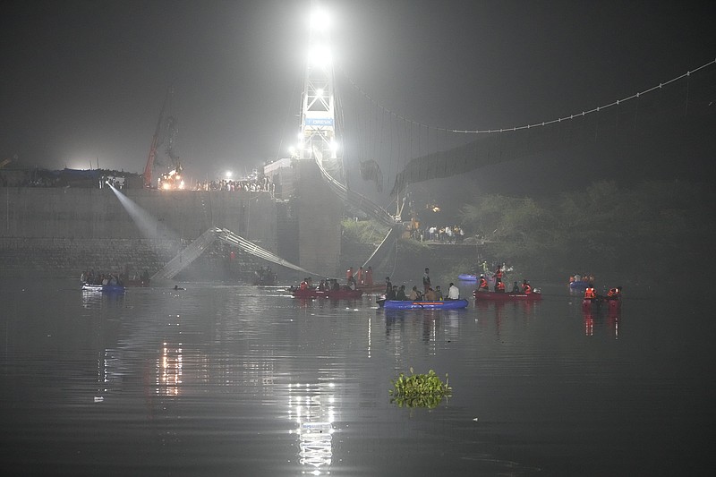 Rescuers on boats search in the Machchu river next to a cable bridge that collapsed in Morbi town of western state Gujarat, India, Monday, Oct. 31, 2022. The century-old cable suspension bridge collapsed into the river Sunday evening, sending hundreds plunging in the water, officials said. (AP Photo/Ajit Solanki)