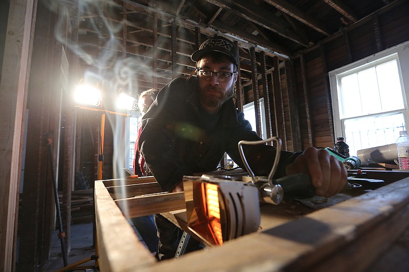 Wyatt Ray uses a heater to fast cure epoxy while restoring windows at the Ernest Green House during the Quapaw Quarter Association's Window Restoration/Weatherization Boot Camp on Thursday, Oct. 27, 2022, in Little Rock. 
(Arkansas Democrat-Gazette/Thomas Metthe)