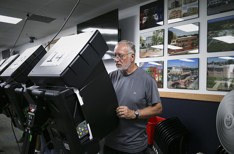 John Leflar votes Monday during early voting at the Benton County Administration Building in Bentonville. (NWA Democrat-Gazette/Charlie Kaijo)