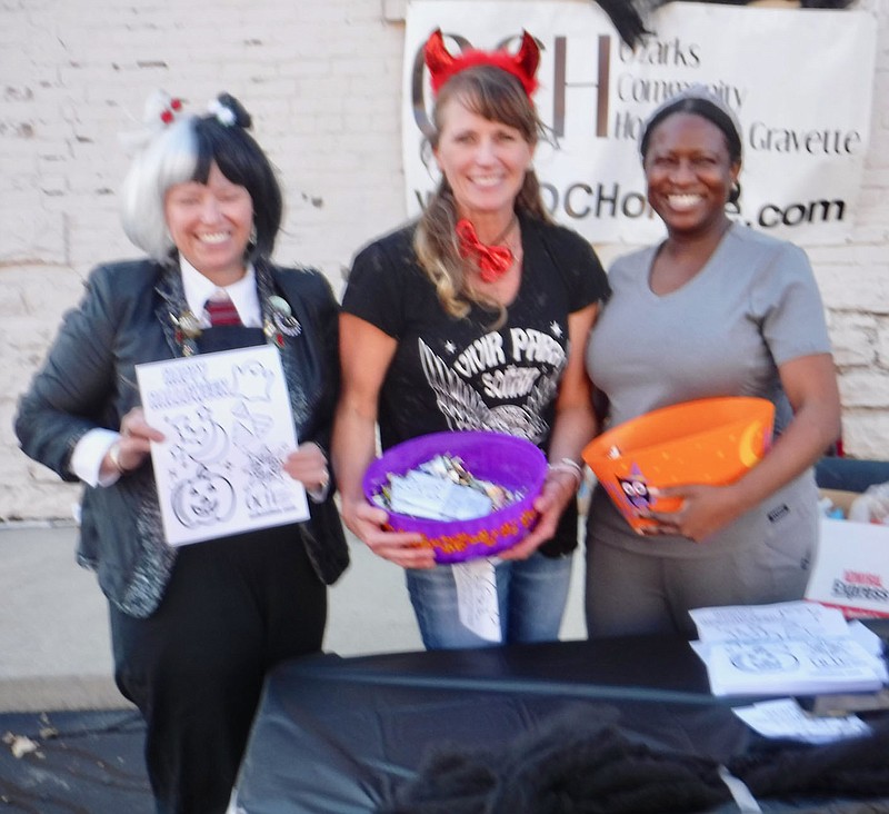 Westside Eagle Observer/SUSAN HOLLAND
Employees from Ozarks Community Hospital pause from offering treats to pose for a photograph. Here Kelly Perrine, Holly Trentham and Winnie Radier await the youngsters with candy and coloring pages to reward the visitors to their booth.