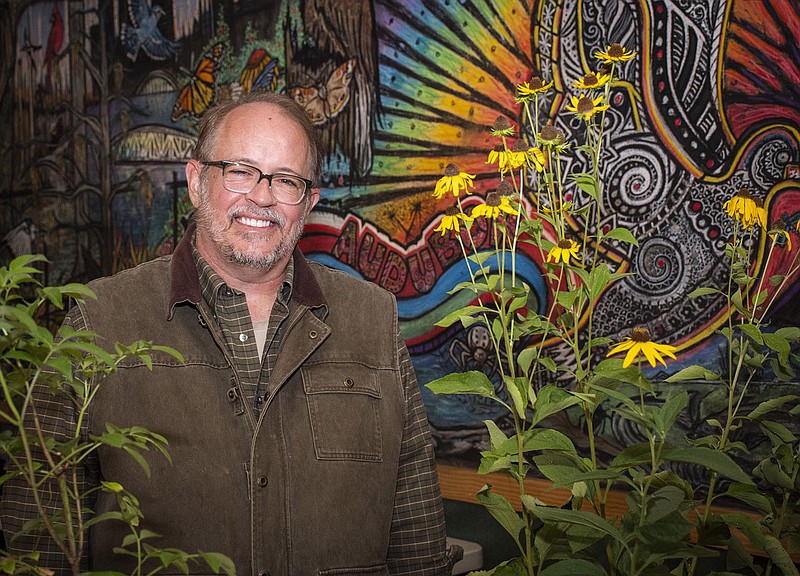 Glen Hooks, policy manager for Audubon Arkansas, with native plants for the non-profits plant sale in front of a mural by Prinn Vandegrift  at Audubon Arkansas on 09/29/2022 for High Profile cover story (Arkansas Democrat Gazette/Cary Jenkins)